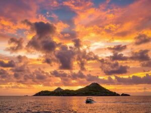 Sunset over Komodo Island with a cruising boat.